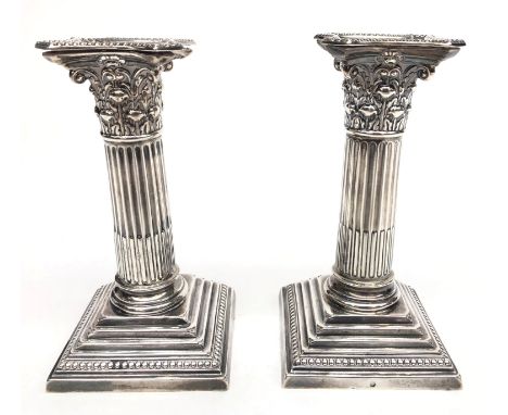 A pair of filled silver Corinthian column candlesticks by William Hutton & Sons Ltd, London 1910, height 15cm. Condition repo