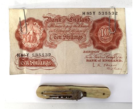 A pocket folding fork and corkscrew, together with a Bank of England 10 shilling note.