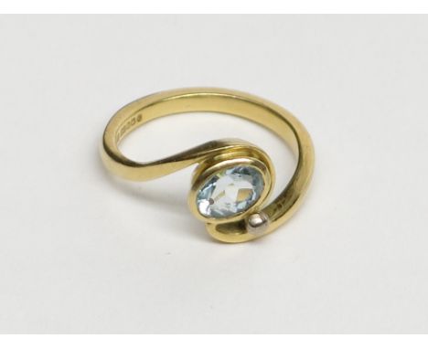 An 18ct gold ring in Art Nouveau style set an aquamarine alongside a white gold bead.