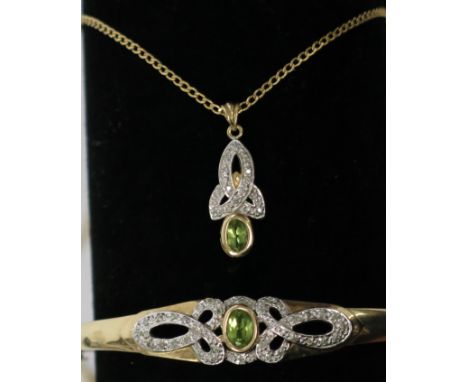 A 9ct gold hinged bangle set with peridot flanked by ribbons of pave set diamonds together with a matching 9ct gold pendant a