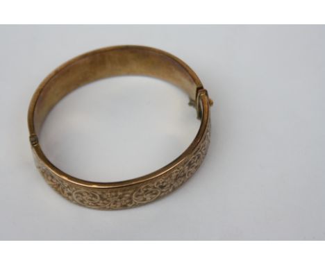 An engraved 9ct gold hinged bangle, 19.6g.