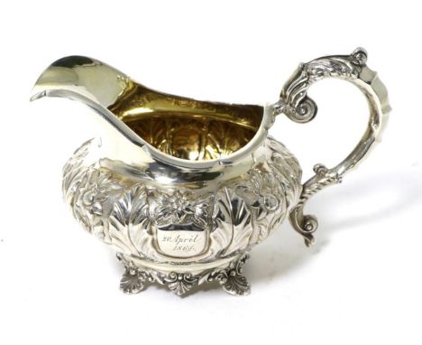 A William IV Silver Cream Jug, John, Henry & Charles Lias, London 1832, squat circular with flowerhead and leaf repousse deco