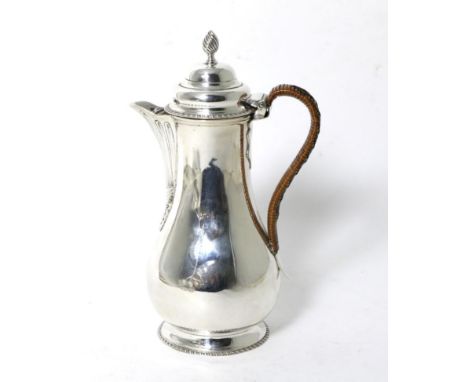 An Edwardian Silver Hot Water Jug of George III Style, Charles Stuart Harris, London 1902, baluster form with gadroon noders,
