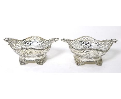 A Pair of Edwardian Pierced Silver Baskets, William Comyns, London 1904, shaped oval form with twin ribbon bow handles, bead 