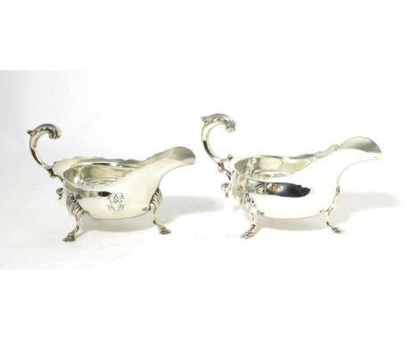 Two Similar George III Style Silver Sauce Boats, London 1898 and 1902, with shaped rim, leaf capped flying scroll handle and 