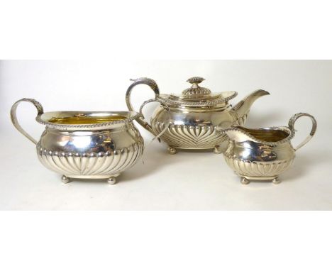 A matched George III three piece silver tea service, part fluted with gadroon border, on ball feet38ozt