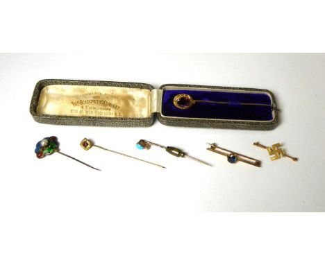 A garnet stickpin, an oval cut garnet in a buckle frame, in a fitted case, a turquoise and diamond stick pin, an enamel and p