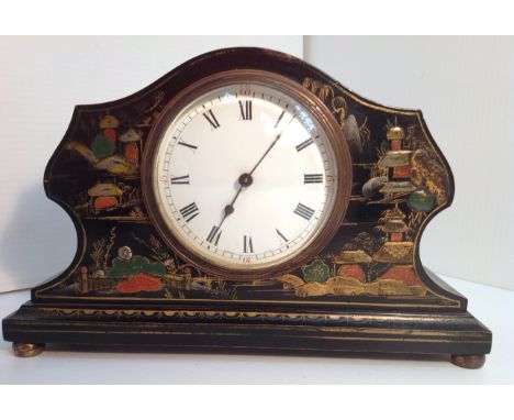 An early 20th century mantel clock, the shaped arched case lacquered and painted in the chinoiserie manner on a black ground,