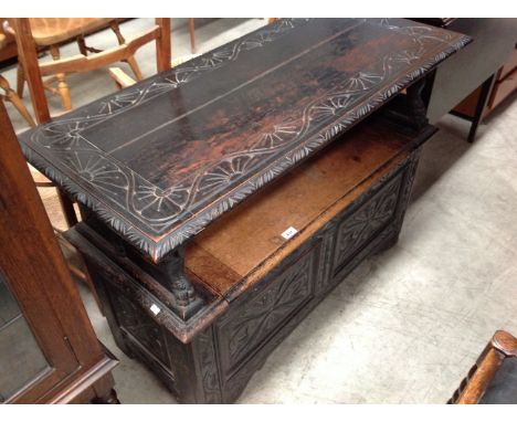 A carved oak monks bench with lift top seat 108cm long 