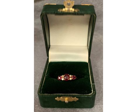 A modern seven stone ruby and diamond dress ring, three claw-set rubies flanking pairs of small diamonds, stamped 750 (approx