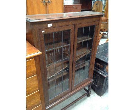 An oak 4 shelf bookcase with leaded glazed doors on squat barley twist legs with stretchers 92 x 140cm high 