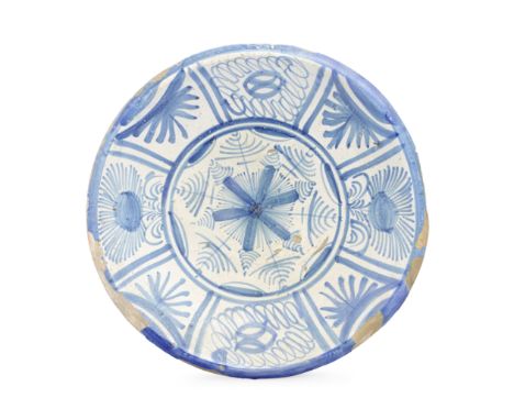 A rare and early London delftware charger, circa 1640Southwark or Rotherhithe, painted in blue with a central daisy-like moti