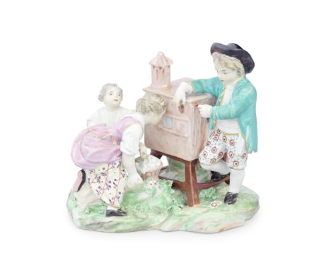 A rare Derby 'Peepshow' group, circa 1800Modelled as three children with a peepshow, a boy standing to one side operating the
