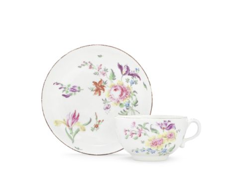 A Worcester teacup and saucer, circa 1770Decorated in the Giles workshop with vibrant flowers and scattered leaves, the cup w