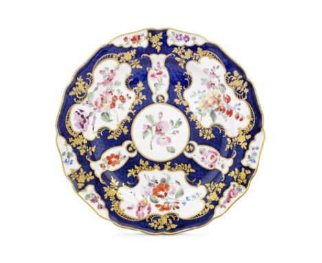 A Worcester plate from the Lord Craven service, circa 1770The blue scale ground reserving rococo shaped panels of colourful f