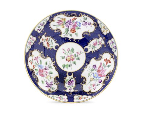 A fine Worcester saucer dish, circa 1770The rich underglaze blue scale ground reserving rococo or mirror-shaped panels, paint