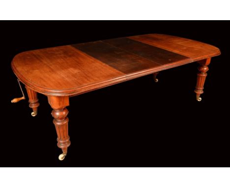 A Victorian mahogany wind-out dining table, moulded rounded rectangular top with two additional leaves, turned and fluted leg