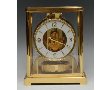 A Jaeger Lecoutre brass Atmos clock, 10.5cm dial with baton markers and Arabic numerals to quarters, skeleton movement with l