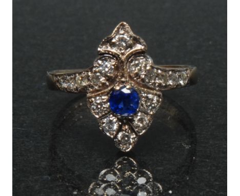 An Art Deco style diamond and sapphire dress ring, shaped navette arrow crest, inset with a single vibrant blue sapphire, app