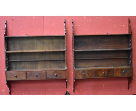 A near pair of Chinese Chippendale design mahogany waterfall wall shelves, each with three tiers above a frieze of drawers, t