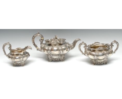 A William IV silver lobed melon shaped three piece tea service, embossed with stiff leaves, berry and leafy borders, acanthus