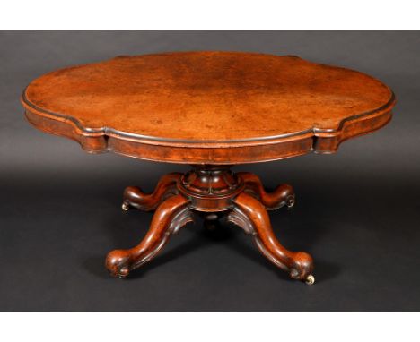 A Victorian burr walnut shaped oval breakfast table, quarter veneered top above a deep frieze, turned column, lotus socle, sc