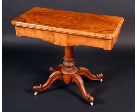 An early Victorian walnut card table, folding rounded rectangular top enclosing an inset playing surface above a deep frieze,