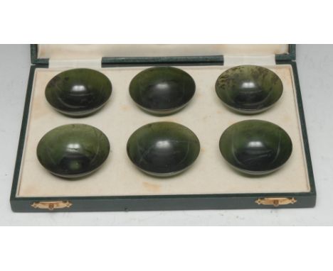 A set of six Chinese spinach jade circular bowls, 6cm diam, retailed by H Simmons, Burlington Arcade, Piccadilly, London, fit