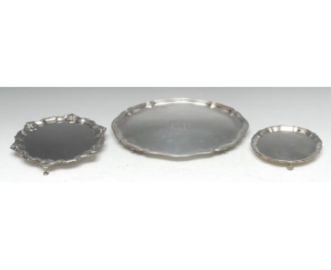 A George V silver shaped circular waiter, of George II design, fluted piecrust border, plain field, hoof feet, 21cm diam, Wil