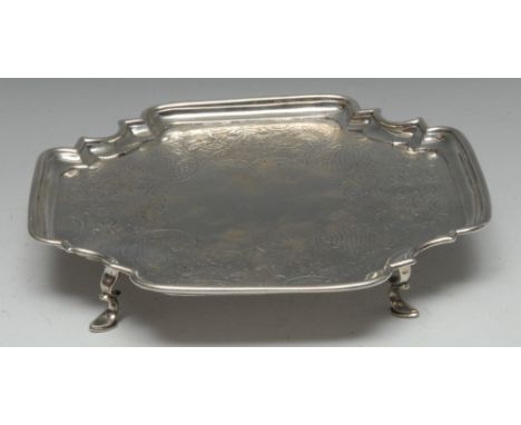 A George II Provincial silver shaped incurved square salver, the field flat chased with a band of flowers, scrolling foliage 
