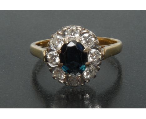 A sapphire and diamond cluster ring, central oval deep blue sapphire approx 7.76mm x 6.13mm x 3.26mm, calculated weight appro