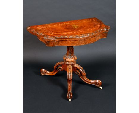 A Victorian walnut and marquetry shaped demi-lune card table, folding top inlaid with a band of scrolling leaves and tendrils