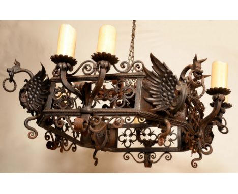 An Arts and Crafts wrought iron chandelier, the sides with pairs of pricket candle sconces, 74cm wide
