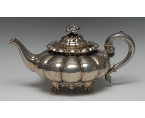 A George IV Provincial silver melon shaped teapot, hinged domed cover with flower finial, scroll-capped handle, C-scroll cart