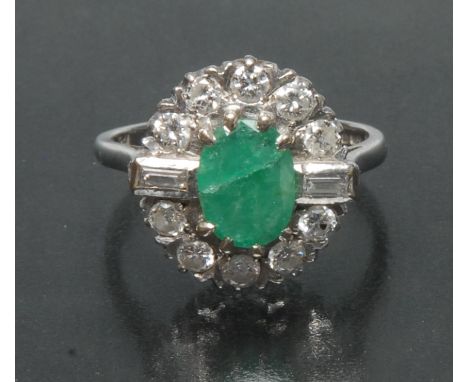 An emerald and diamond cluster ring, central oval emerald, approx 9.03mm x 6.75mm, x 2.01mm, calculated approx weight  0.60ct