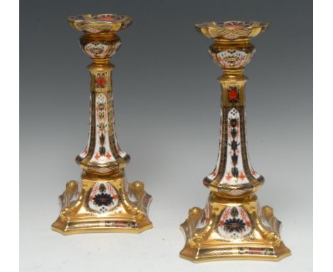 A pair of Royal Crown Derby 1128 pattern Castleton candlesticks, dolphin to angles, incurved square bases, printed marks Cond