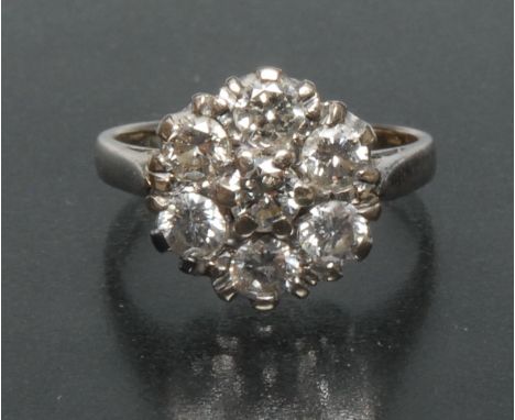 A diamond flower cluster ring, central raised round brilliant cut diamond approx 0.25ct, surrounded by a band of six conformi