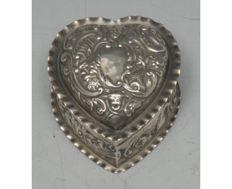 A Victorian silver heart shaped dressing table trinket box, embossed overall with masks, dolphins and leafy scrolls, wavy bor