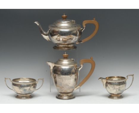 A George VI silver four piece tea service, comprising teapot, water pot, milk jug and sugar basin, hinged domed cover with kn