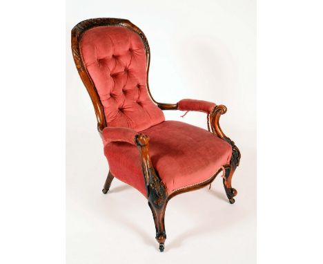 A Victorian walnut spoonback elbow chair, carved throughout with acanthus scrolls, stuffed over upholstery, cabriole legs, ce