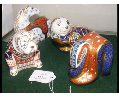 A collection of four Royal Crown Derby paperweights including sea lion 