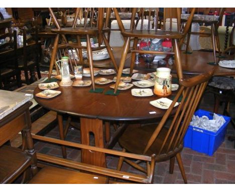 An extending Ercol dining table with the matching set of four chairs