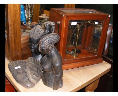 A set of laboratory scales in glass case, together with carved wooden African figures 