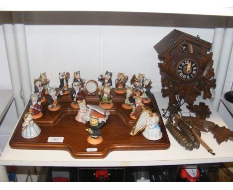 A 'cat orchestra' on display stand, together with a cuckoo clock  