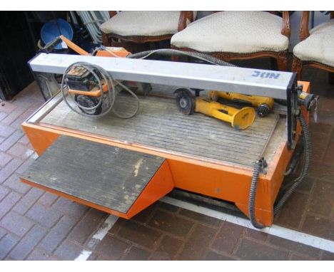 A large tile cutter together with three Dewalt power tools lacking batteryCONDITION REPORTThe three DeWalt tools are as follo