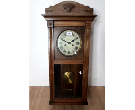 AN OAK CASED WALL CLOCK