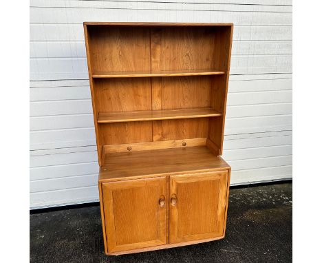 Ercol – an Ercol Windsor blond elm bookcase cabinet with two adjustable shelves, over double cupboard doors, enclosing a cutl