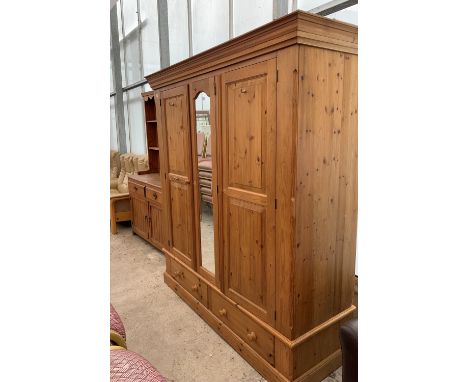 A PINE TRIPLE WARDROBE WITH TWO DOORS AND MIRRORED CENTRE PANEL 