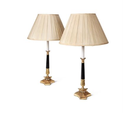 A PAIR OF EBONISED AND GILT METAL LAMP BASES  20TH CENTURY IN THE EMPIRE MANNER  78.5cm high to top of existing shade  