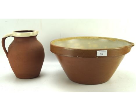 A large partially glazed wash bowl and jug, the basin measuring 36cm diameter, the jug 21cm high
